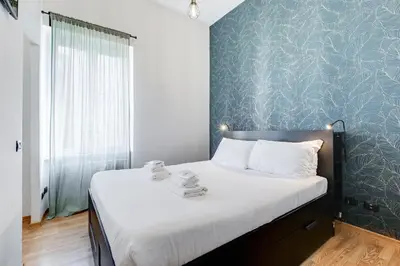 a bedroom with a bed with a blue wall at Salotto San Pietro in Rome