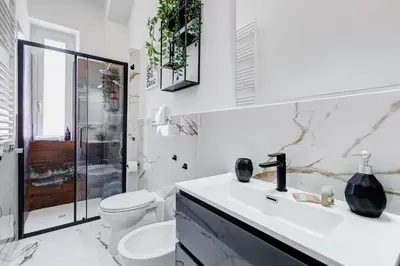 a white bathroom with a toilet and a sink at Salotto San Pietro in Rome