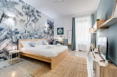 a bedroom with a bed with a tropical wallpaper at CasaVibe Vaticano in Rome