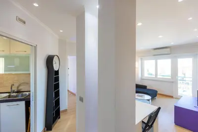 a kitchen and a living room with a clock on a wall at Piramide view by Rental in Rome in Rome