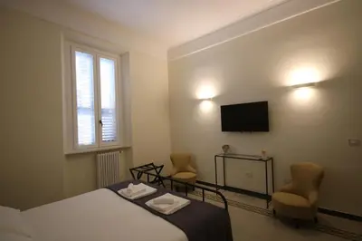 a bedroom with a bed and two chairs and a television at Irene's Home The Retreat in Rome