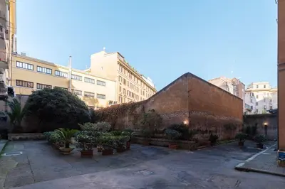 a courtyard with potted plants in front of buildings at GuestHost - Roma Trastevere Vibes Apartment in Rome