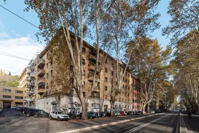 a building on a street with cars parked in front at GuestHost - Roma Trastevere Vibes Apartment in Rome