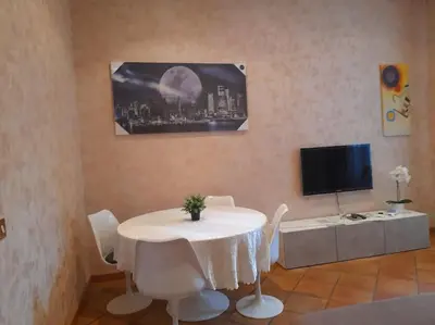 a dining room with a white table and a tv at Allegra’s House Barberini in Rome