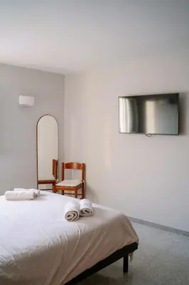 a bedroom with a bed with a mirror and a chair at Romantic apartment [Metro A Ponte Lungo] in Rome