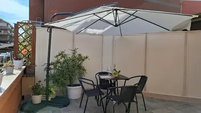 a table and chairs under an umbrella on a patio at FaMaCrì Home in Rome