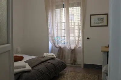 a bedroom with a bed and a window with curtains at Casa di Pera in Rome