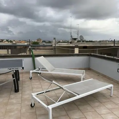 a white chair sitting on top of a roof at Trastevere Attic Raffaello’s rooms in Rome