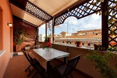 a patio with a table and chairs on a balcony at CAVALLEGGERI HOUSE in Rome
