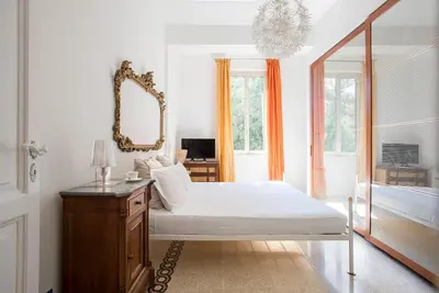 a bedroom with a bed and a mirror and a desk at Vittoria in Trastevere Apartment in Rome