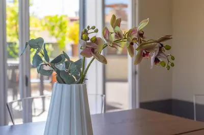 a white vase with flowers in it on a table at iFlat Magical flat by the Tiber in Rome
