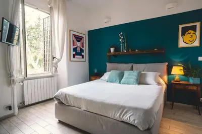 a bedroom with a large bed with a blue wall at Vaticano/Trastevere Floreal Suite in Rome