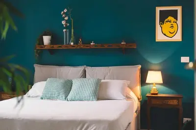 a blue bedroom with a bed with two pillows at Vaticano/Trastevere Floreal Suite in Rome