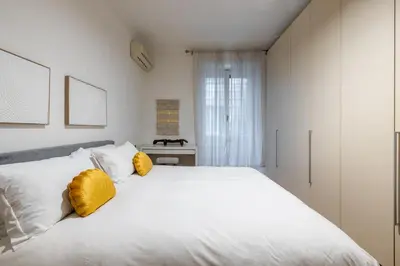 a bedroom with a large white bed with yellow pillows at Urban Chic 2 BR Vatican Escape in Rome