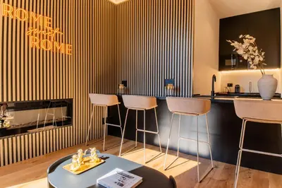 a kitchen with a bar with stools and a fireplace at Scipioni Luxury Suite (3 camere, 3 bagni) in Rome