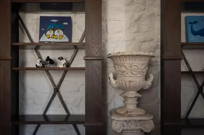 a shelf with a vase and some pictures on it at Merulana Penthouse: 5 minutes WALK from Colosseum in Rome