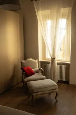 a living room with a chair and a window at Merulana Penthouse: 5 minutes WALK from Colosseum in Rome