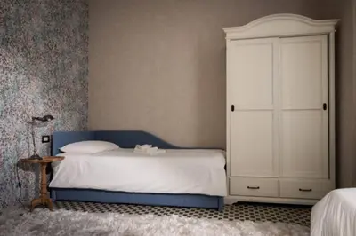 a bedroom with a bed and a white cabinet at Merulana Penthouse: 5 minutes WALK from Colosseum in Rome