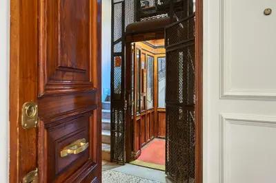 an open wooden door with a reflection of a hallway at Vatican 2BR Walk to St Peters IREX Apartment in Rome