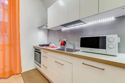 a kitchen with white cabinets and a microwave and a sink at TRASTEVERE SUITE EXPERIENCE in Rome