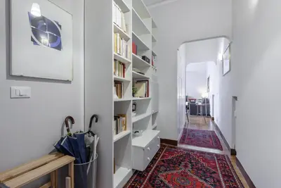 a hallway with bookshelves and a rug at Charming Apartment Piazza del Popolo in Rome