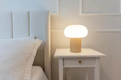 a lamp on a nightstand next to a bed at Giò House - Palazzo Storico in Rome