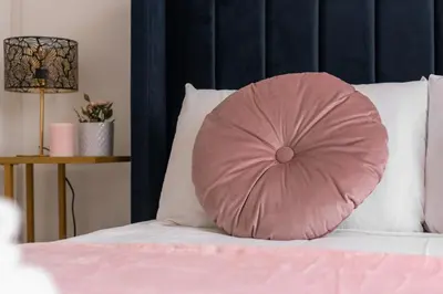 a pink pillow sitting on top of a bed at Appartamento via di Porta Labicana in Rome