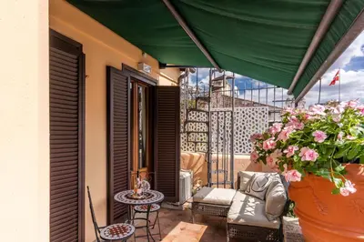 a balcony with a couch and a table and flowers at Twilight Terrace - Piazza di Spagna in Rome