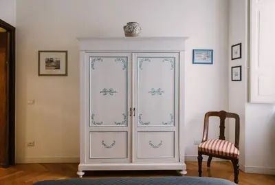 a white cabinet in a room with a chair at Appartamento Roma Vaticano 