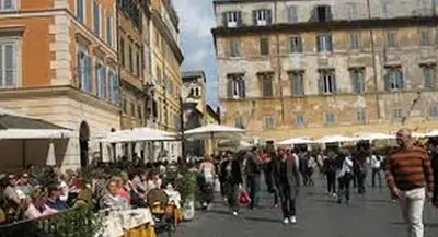 a crowd of people walking down a street with buildings at Gio' Suites in Rome