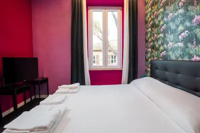 a bedroom with a white bed and a window at SABA SUITE ROMA in Rome