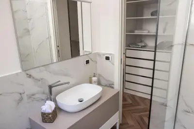 a white bathroom with a sink and a mirror at Casa Matteo53, Termini in Rome