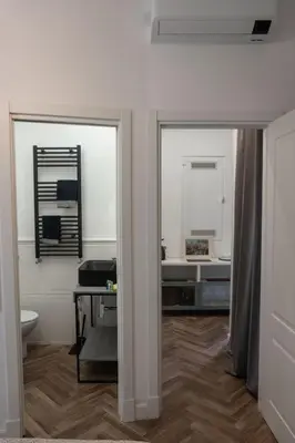 a bathroom with a toilet and a desk with a mirror at Casa Matteo53, Termini in Rome
