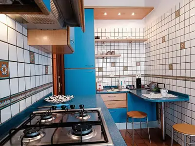 a kitchen with a stove and a blue wall at Appartamento per le tue vacanze a Roma Villa Pamphili in Rome