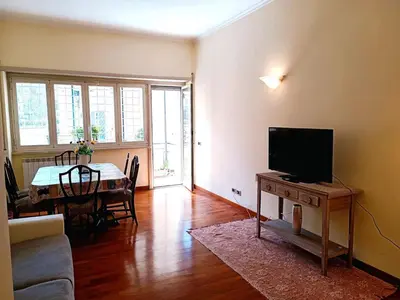 a living room with a television and a table with a tableablish at Appartamento per le tue vacanze a Roma Villa Pamphili in Rome