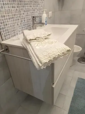 a white bathroom with a sink and a towel at House Vaticano in Rome