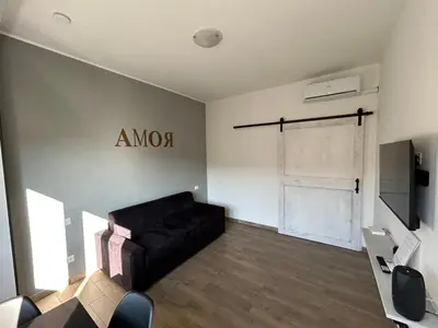 a living room with a black couch and a television at CASA LINO in Rome