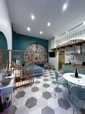 a living room with a kitchen and a room with a table at LOFT 125 passi dal Colosseo in Rome