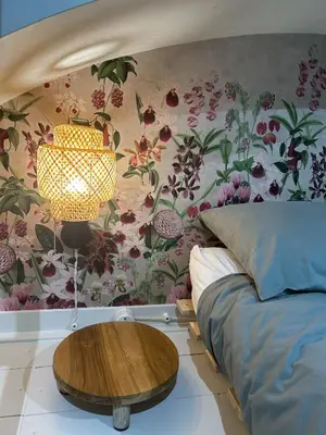 a bedroom with a bed with a table and a flower wall at LOFT 125 passi dal Colosseo in Rome