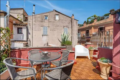 a patio with a table and chairs on a balcony at Attico Campo de Fiori Katia in Rome