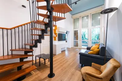 a spiral staircase in a living room with a couch at Loft Porta Maggiore in Rome