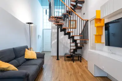 a living room with a couch and a staircase at Loft Porta Maggiore in Rome