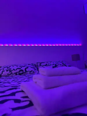 a bedroom with purple lighting and a bed with pillows at Dolce Vita Rooms Monteverde Trastevere in Rome