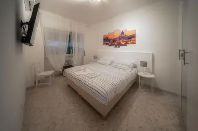 a white bedroom with a bed and two tables at Dolce Vita Rooms Monteverde Trastevere in Rome