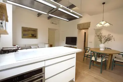 a kitchen and dining room with a table and a kitchen and a living room at Magnolia House in Testaccio in Rome