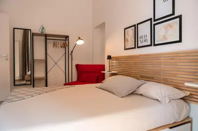 a bedroom with a large bed and a red chair at Re di Roma apartment in Rome