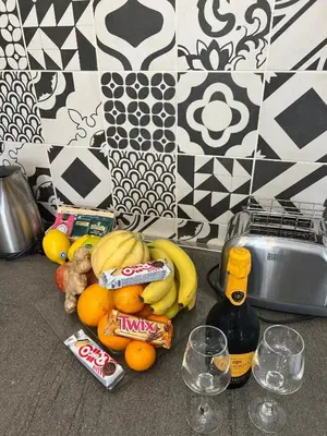 a pile of fruit on a counter with a bottle of wine at Casa Bravetta - Parking Private in Rome