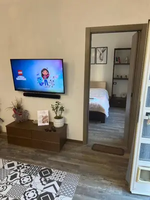 a living room with a flat screen tv and a bedroom at Casa Bravetta - Parking Private in Rome