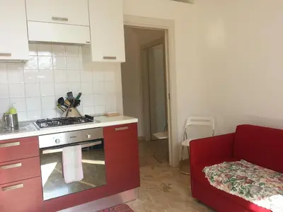 a kitchen with red cabinets and a stove top oven at Between Termini & Colosseo in Rome