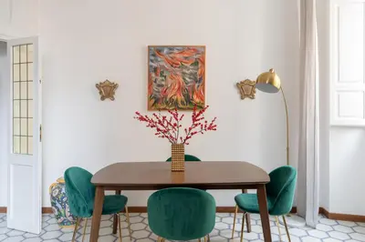 a dining room with a table and green chairs at iFlat Barberini 's Dream in Rome